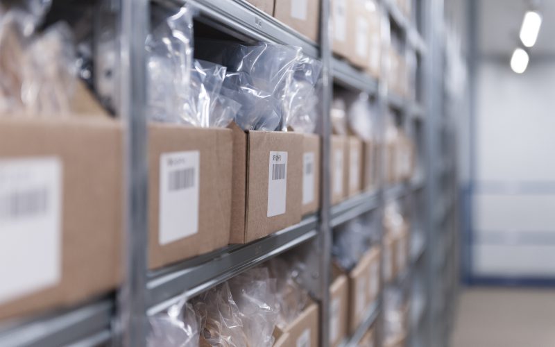 Getting your stock right at peak shopping times is critical: image depicts a row of cardboard boxes filled with stock in a neat and organised warehouse.